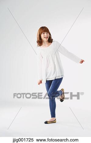 Stock Photography - Full length portrait of young Japanese woman against white background. Fotosearch