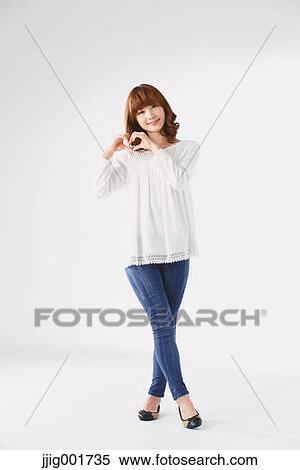 Stock Photography - Full length portrait of young Japanese woman against white background. Fotosearch