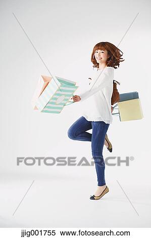 Stock Photography - Full length portrait of young Japanese woman against white background. Fotosearch