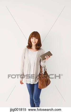 Stock Photography - Full length portrait of young Japanese woman against white background. Fotosearch