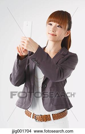 Half length portrait of Japanese young businesswoman against white background View Large Photo Image Picture - Half length portrait of Japanese young businesswoman against white background. Fotosearch