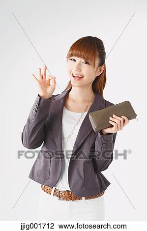 Stock Image - Half length portrait of Japanese young businesswoman against white background. Fotosearch