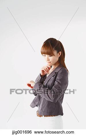 Stock Photograph - Half length portrait of Japanese young businesswoman against white background. Fotosearch