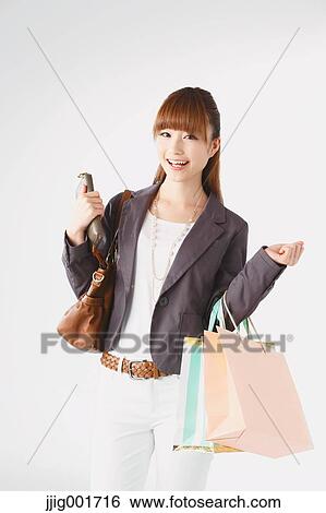 Stock Photograph - Half length portrait of Japanese young businesswoman against white background. Fotosearch