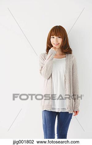 Stock Image - Half length portrait of young Japanese woman against white background. Fotosearch