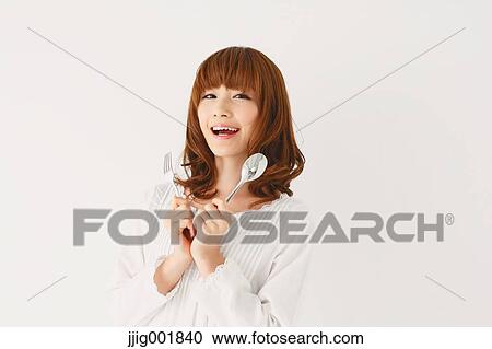 Stock Image - Half length portrait of young Japanese woman against white background. Fotosearch