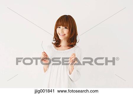 Stock Image - Half length portrait of young Japanese woman against white background. Fotosearch
