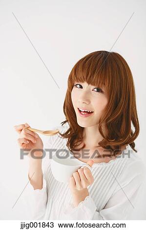 Stock Image - Half length portrait of young Japanese woman against white background. Fotosearch