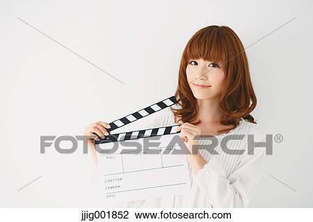 Stock Image - Half length portrait of young Japanese woman against white background. Fotosearch