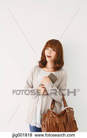 Stock Photo - Half length portrait of young Japanese woman against white background. Fotosearch