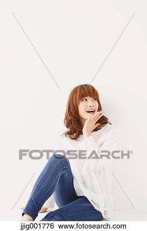 Stock Photograph - Half length portrait of young Japanese woman against white background. Fotosearch