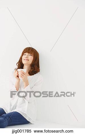 Stock Photography - Half length portrait of young Japanese woman against white background. Fotosearch