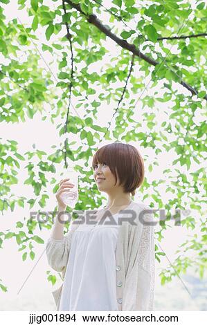 Picture - Portrait of young Japanese woman in a park. Fotosearch