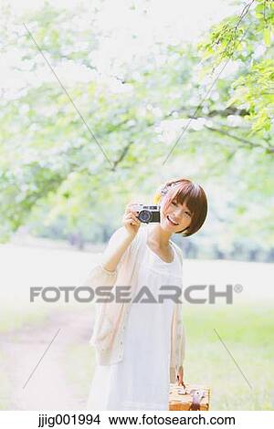 Picture - Portrait of young Japanese woman in a park. Fotosearch