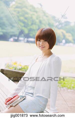 Stock Image - Portrait of young Japanese woman in a park. Fotosearch