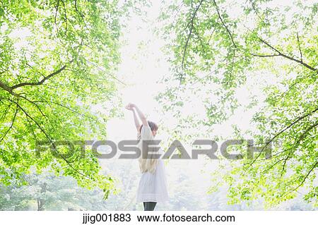 Stock Image - Portrait of young Japanese woman in a park. Fotosearch
