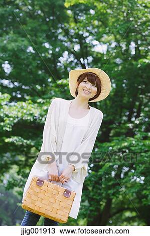 Stock Image - Portrait of young Japanese woman in a park. Fotosearch