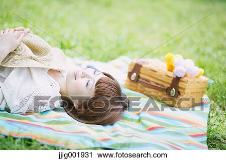 Stock Image - Portrait of young Japanese woman in a park. Fotosearch