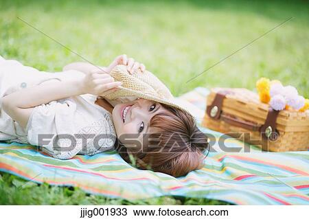 Stock Image - Portrait of young Japanese woman in a park. Fotosearch