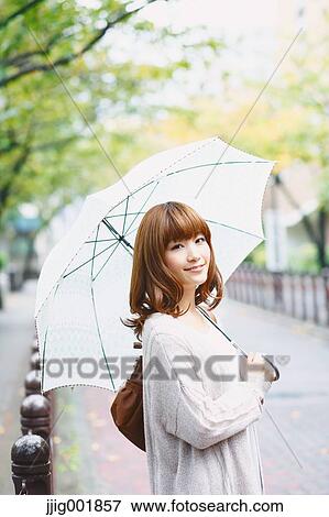 Portrait of young Japanese woman in a park View Large Photo Image Stock Photo - Portrait of young Japanese woman in a park. Fotosearch