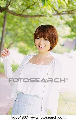 Stock Photo - Portrait of young Japanese woman in a park. Fotosearch