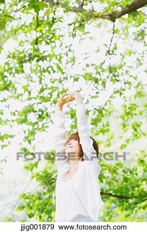 Stock Photo - Portrait of young Japanese woman in a park. Fotosearch