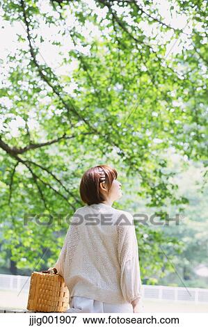 Stock Photo - Portrait of young Japanese woman in a park. Fotosearch