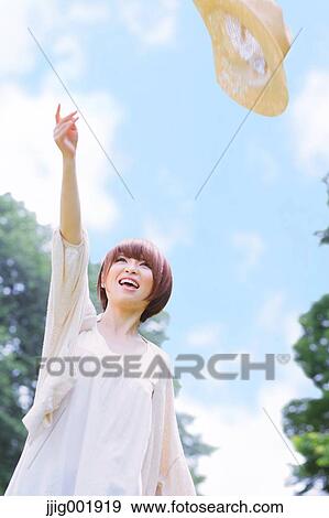 Stock Photo - Portrait of young Japanese woman in a park. Fotosearch