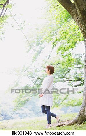 Stock Photo - Portrait of young Japanese woman in a park. Fotosearch