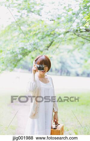 Portrait of young Japanese woman in a park View Large Photo Image Stock Photo - Portrait of young Japanese woman in a park. Fotosearch
