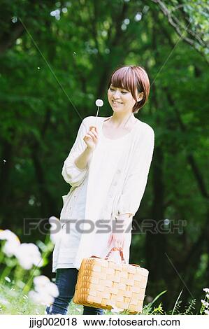 Stock Photo - Portrait of young Japanese woman in a park. Fotosearch