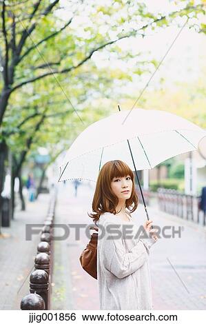 Stock Photograph - Portrait of young Japanese woman in a park. Fotosearch