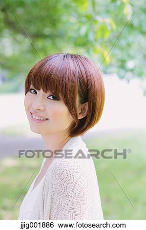 Stock Photograph - Portrait of young Japanese woman in a park. Fotosearch