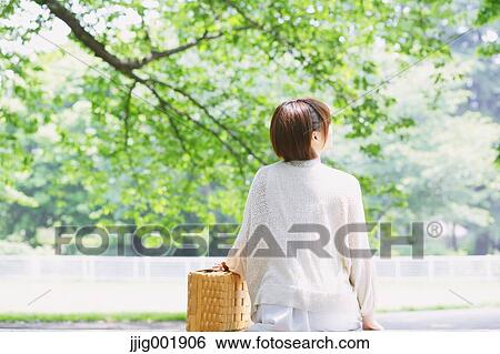 Portrait of young Japanese woman in a park View Large Photo Image Stock Photograph - Portrait of young Japanese woman in a park. Fotosearch