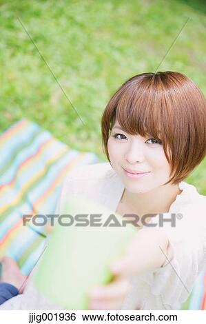 Portrait of young Japanese woman in a park View Large Photo Image Stock Photograph - Portrait of young Japanese woman in a park. Fotosearch