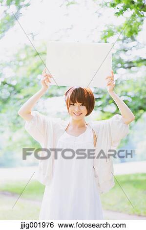 Stock Photograph - Portrait of young Japanese woman in a park. Fotosearch