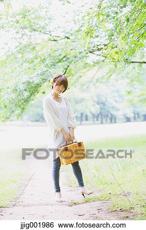 Portrait of young Japanese woman in a park View Large Photo Image Stock Photograph - Portrait of young Japanese woman in a park. Fotosearch