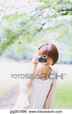 Portrait of young Japanese woman in a park View Large Photo Image Stock Photograph - Portrait of young Japanese woman in a park. Fotosearch