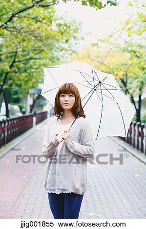 Stock Photography - Portrait of young Japanese woman in a park. Fotosearch