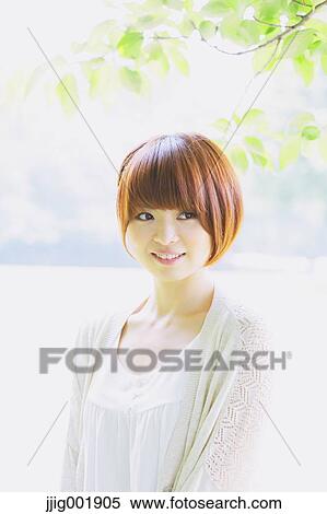 Stock Photography - Portrait of young Japanese woman in a park. Fotosearch