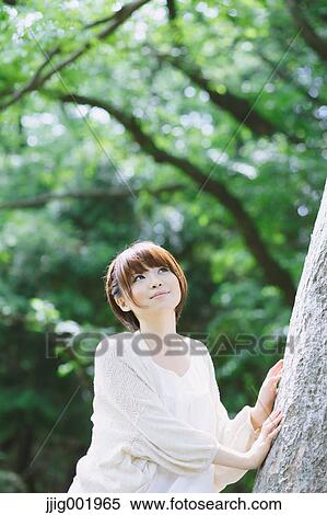 Stock Photography - Portrait of young Japanese woman in a park. Fotosearch
