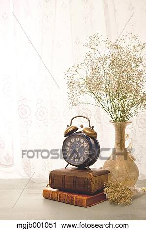 Stock Image - Potted flowers books and clock. Fotosearch