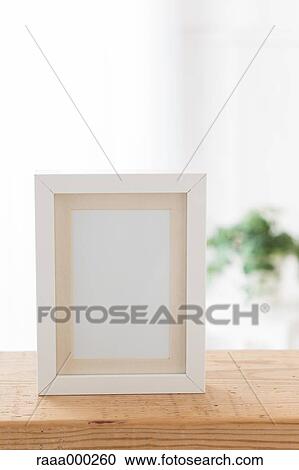 Empty photo frame on wooden table View Large Photo Image Stock Image - Empty photo frame on wooden table. Fotosearch