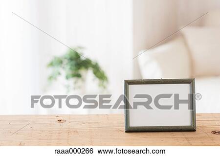 Empty photo frame on wooden table View Large Photo Image Stock Photograph - Empty photo frame on wooden table. Fotosearch