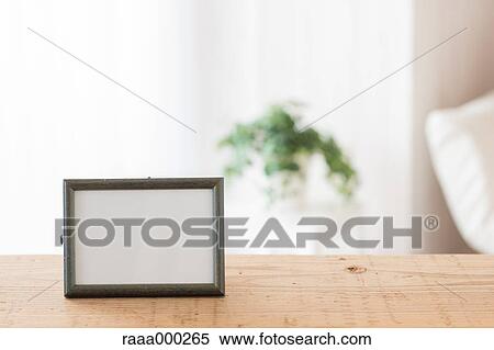 Stock Photography - Empty photo frame on wooden table. Fotosearch