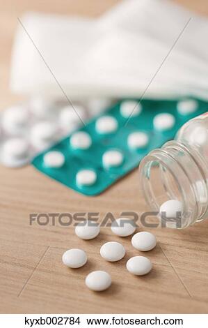 Picture - Pills on wooden table. Fotosearch