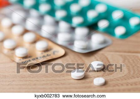 Stock Image - Pills on wooden table. Fotosearch