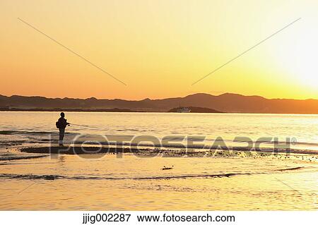 Stock Photo - "Fisherman at sea at sunset, Chiba Prefecture, Japan". Fotosearch