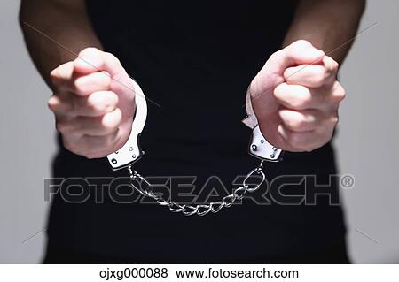 Stock Photo - Handcuffed arms. Fotosearch