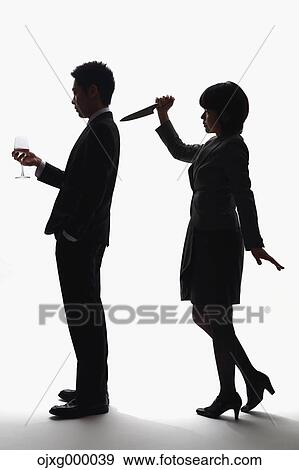 Stock Photo - Japanese businesswoman holding kitchen knife against colleague. Fotosearch